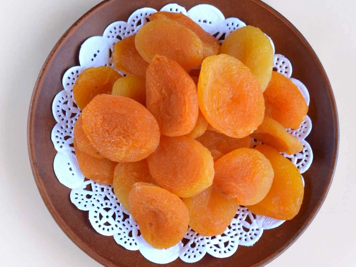 A plate of dried apricot halves on a white background