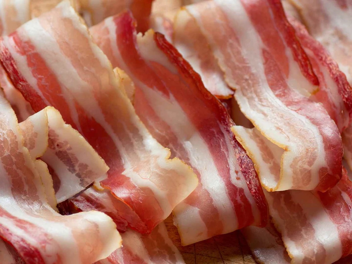 Raw streaky bacon slices piled closely together.