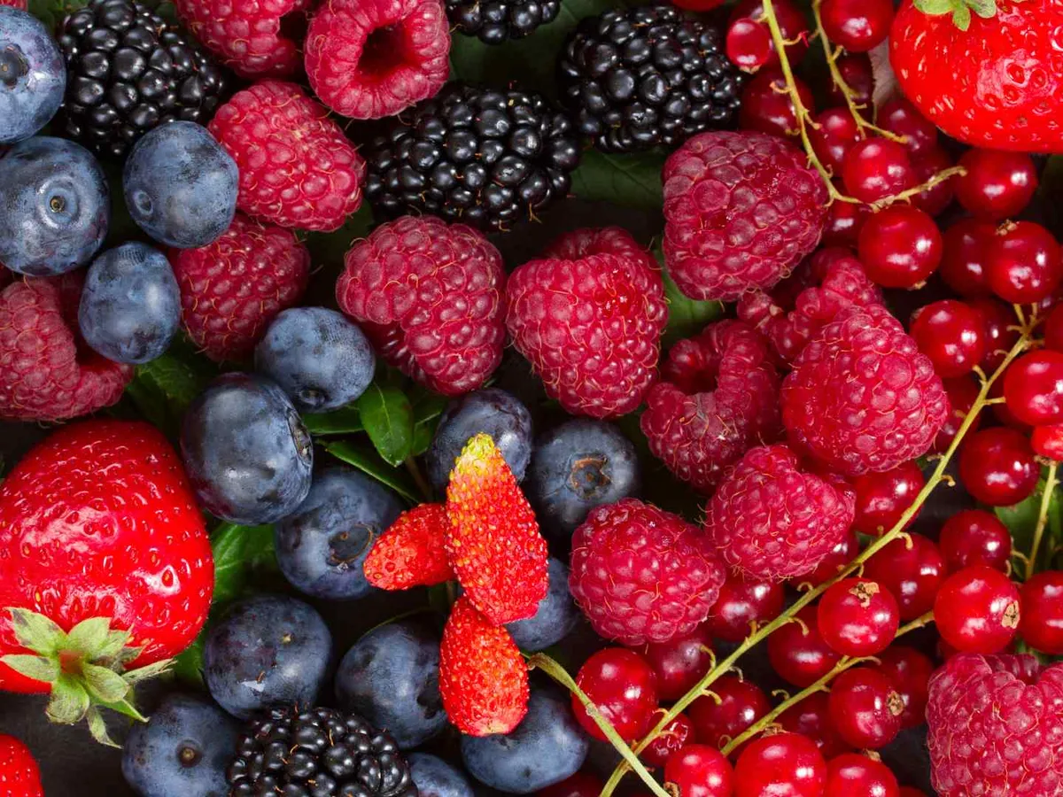Strawberries, blueberries, raspberries, blackberries, and red currants fill the frame.