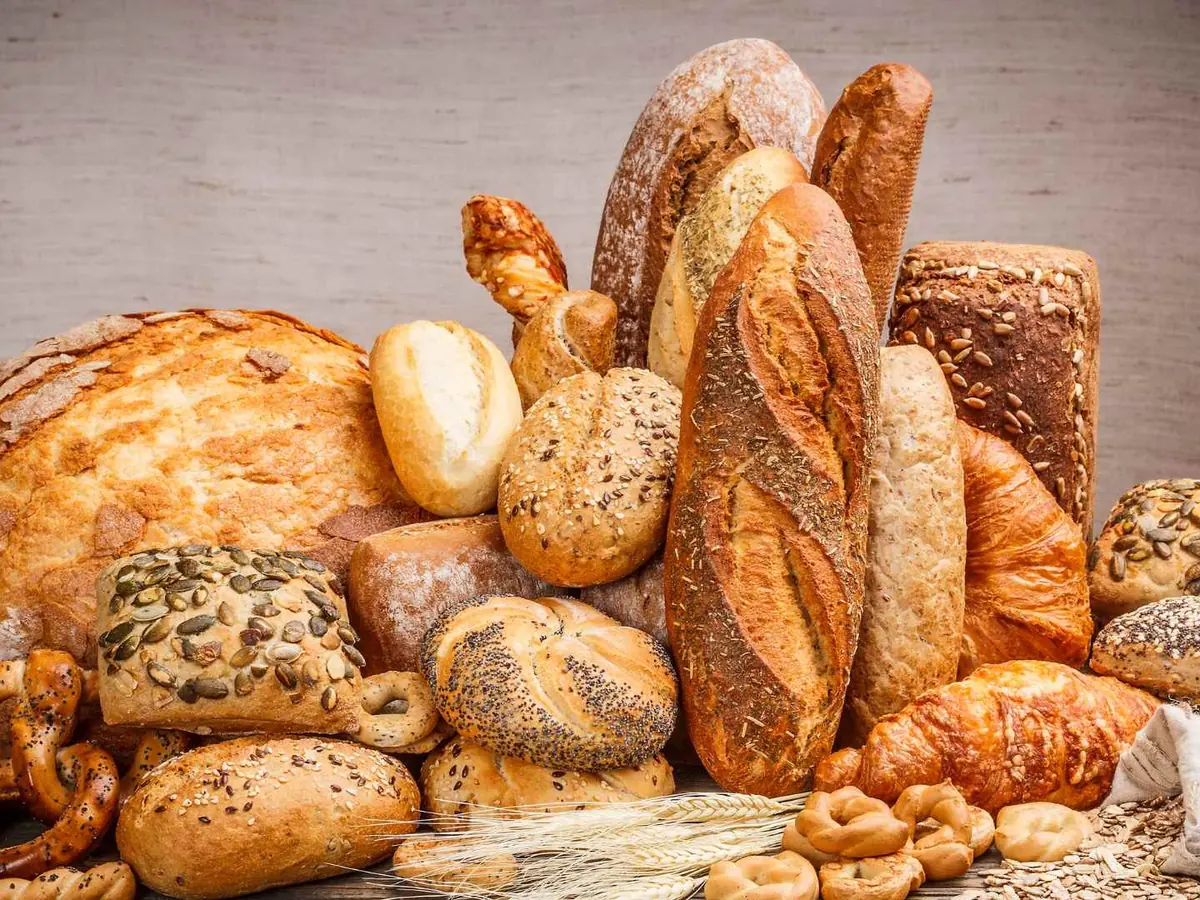 An assortment of loaves and rolls arranged on a wooden table