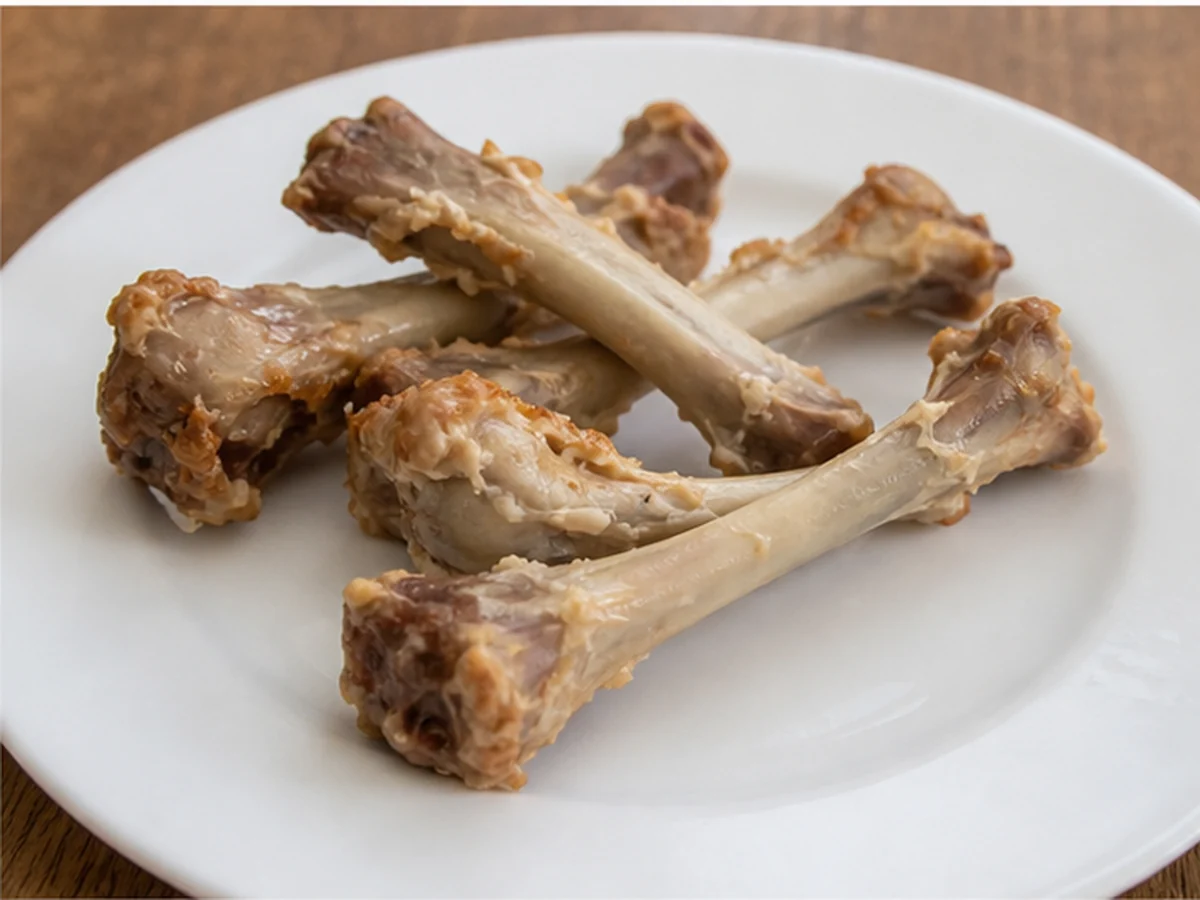 Cooked chicken bones on a white plate
