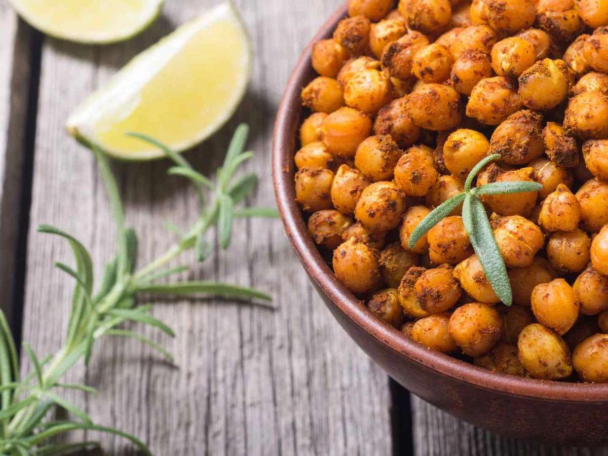 Roasted seasoned chickpeas in a bowl with lime and rosemary.