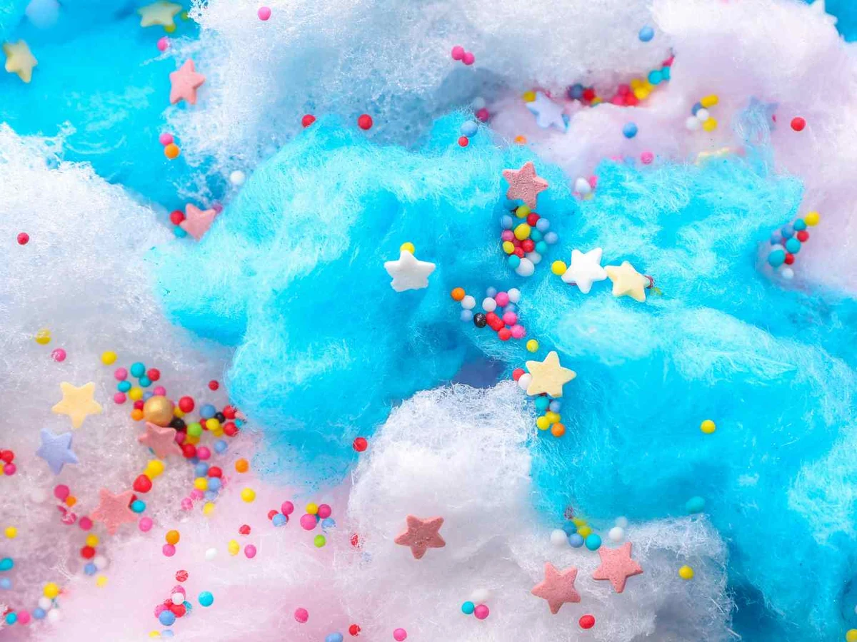 Blue, pink, and white cotton candy decorated with colorful sprinkles.