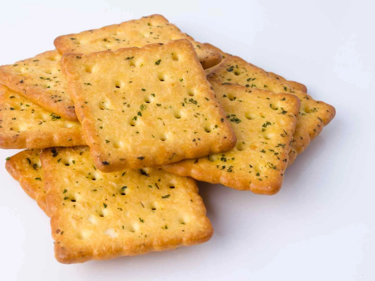 A stack of square herb-seasoned crackers on white