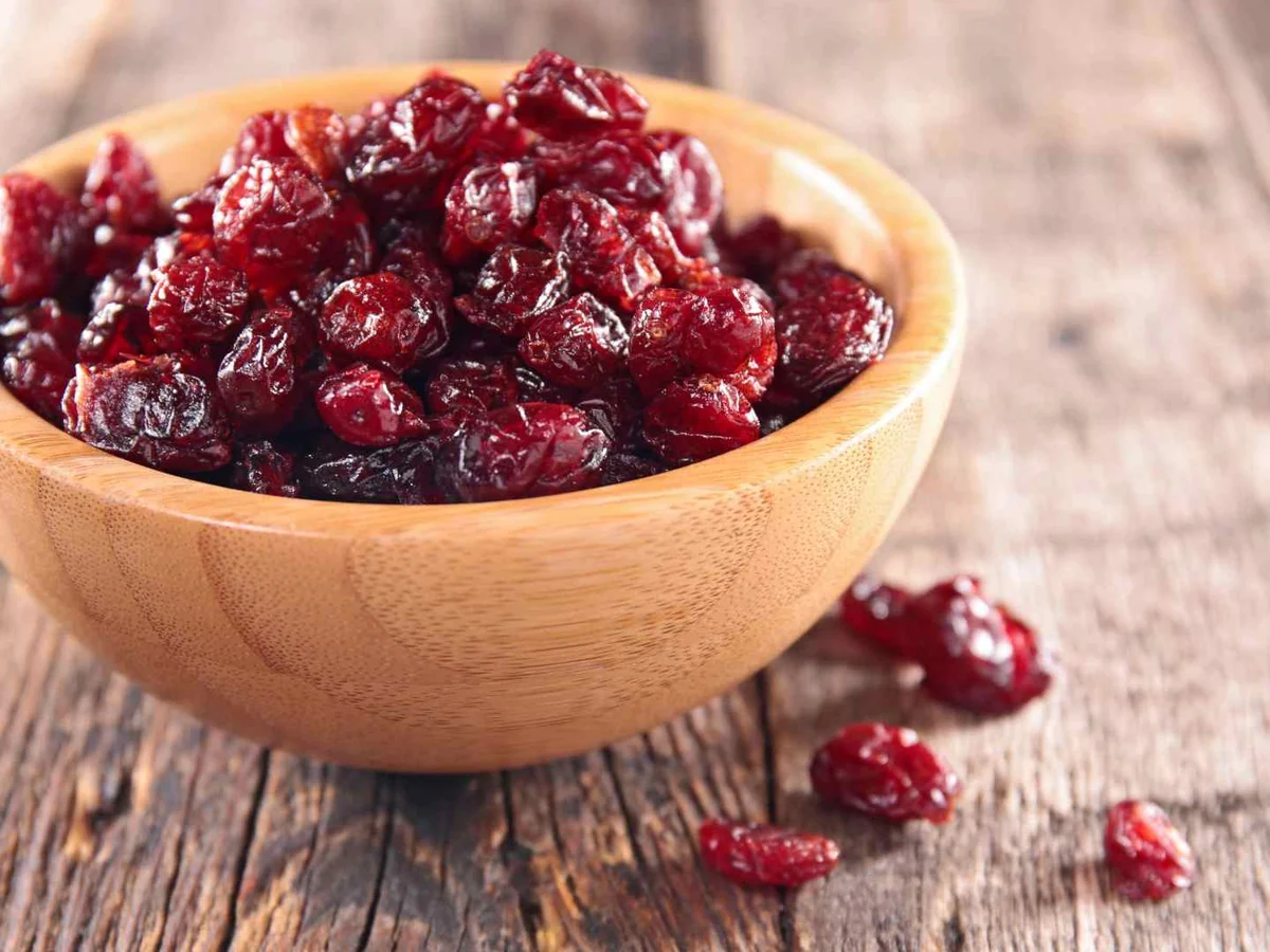 A wooden bowl filled with dried cranberries