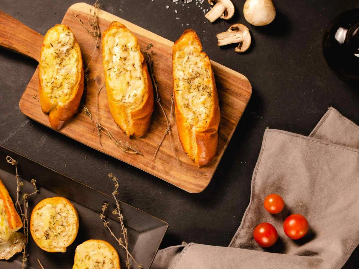 Several pieces of toasted garlic bread on a black tabletop