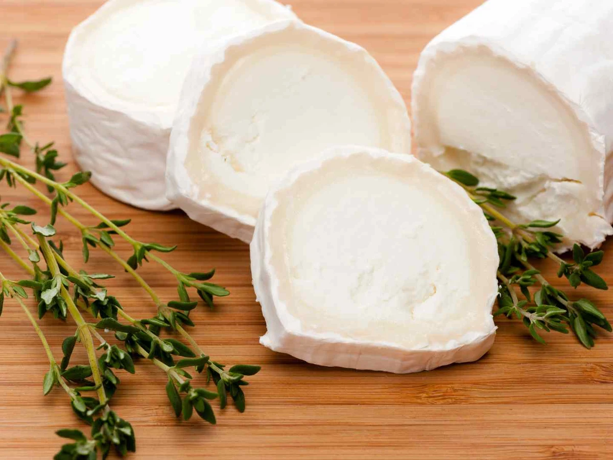 Soft white goat cheese logs and slices garnished with thyme.