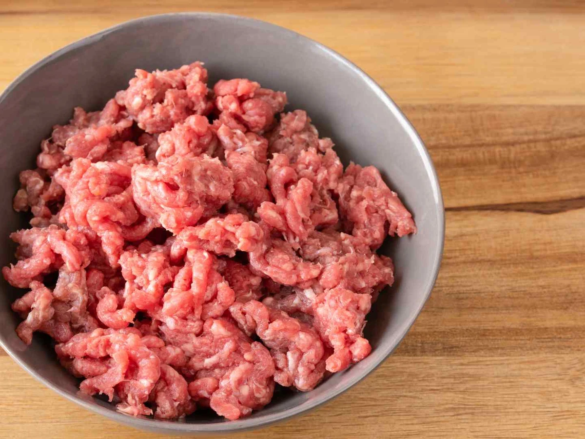 Raw ground turkey crumbles filling a gray bowl.