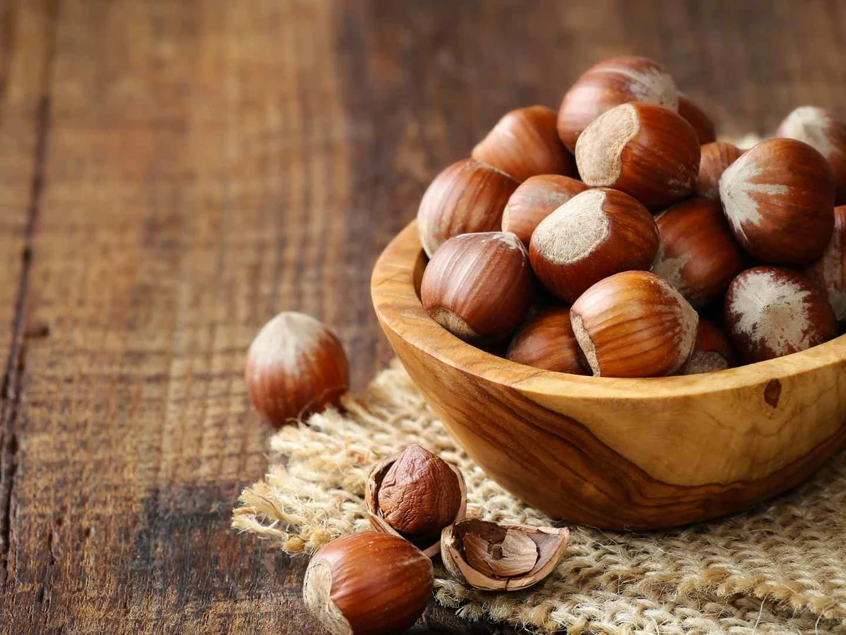 Shelled and unshelled hazelnuts in a wooden bowl