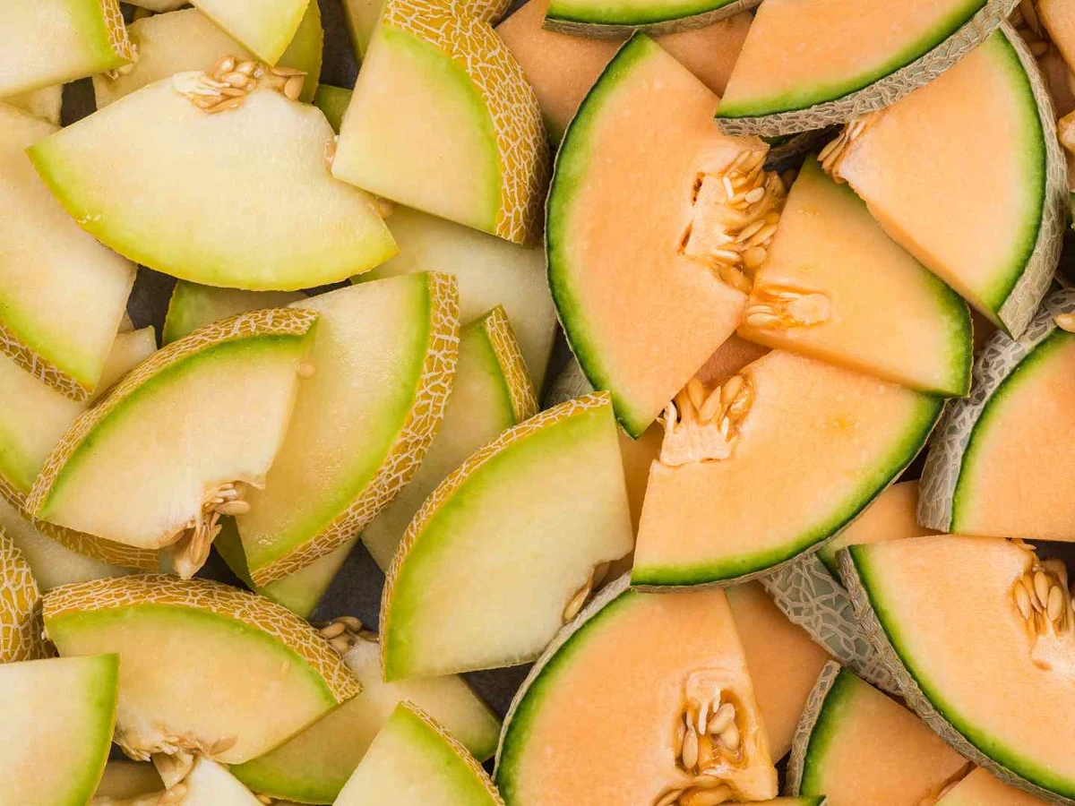 A cut honeydew melon with a decorative spiral of pale green slices.