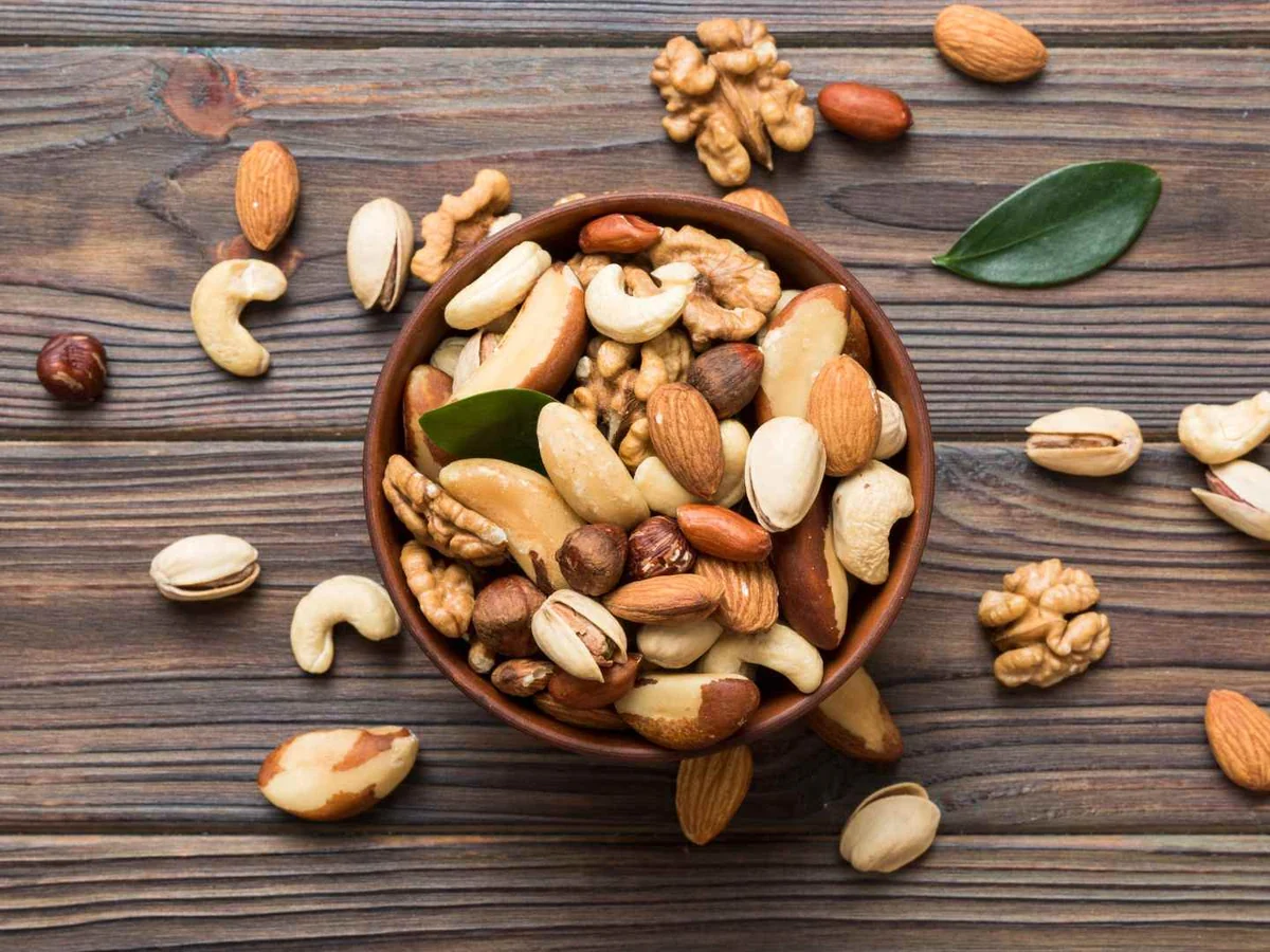 A bowl of mixed nuts on a rustic wooden table