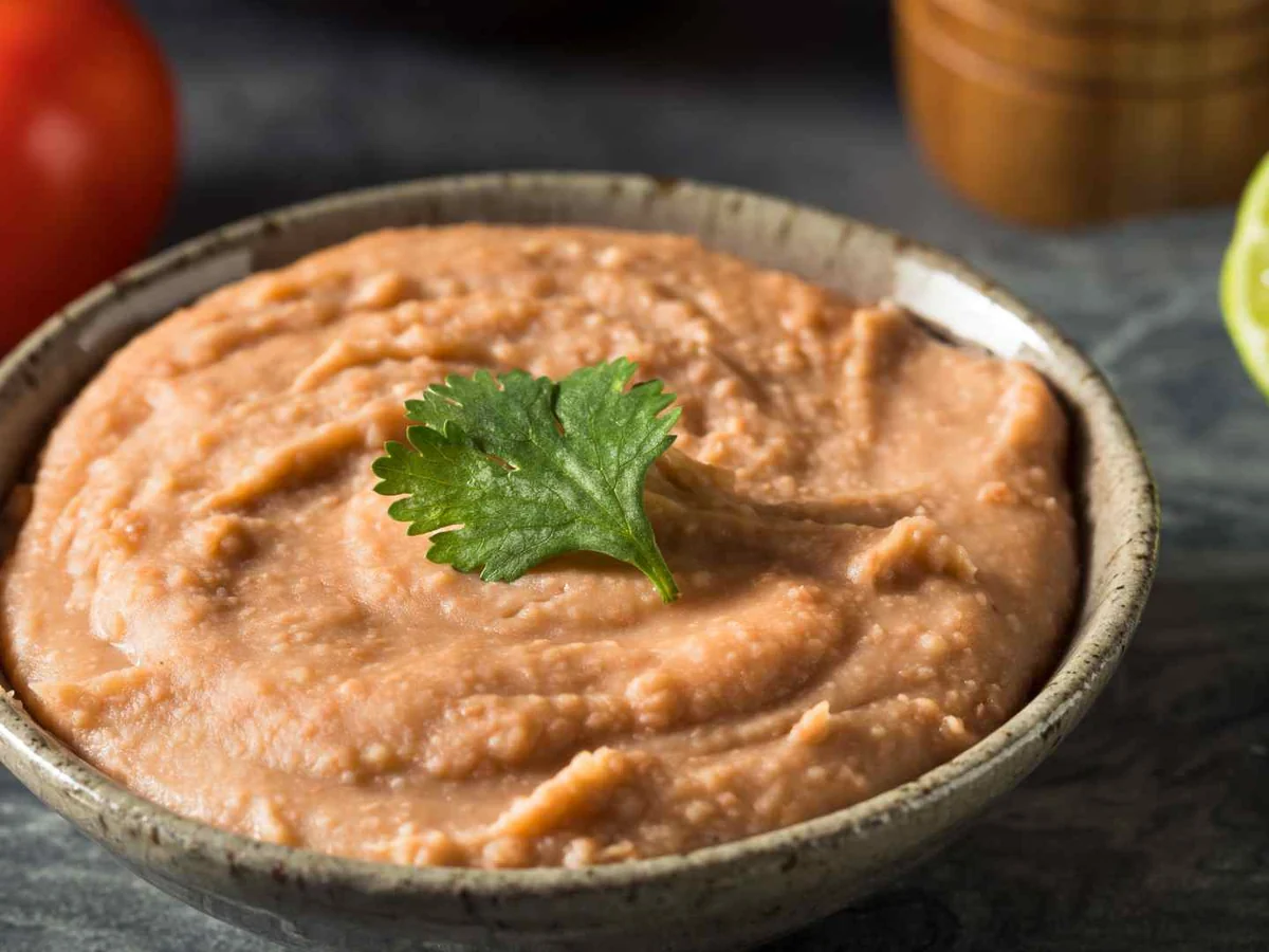 A bowl of refried beans garnished with cilantro
