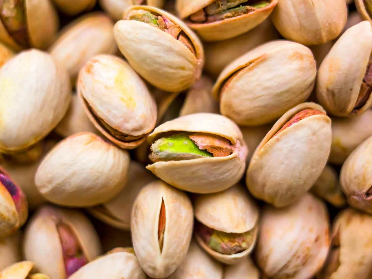 Roasted pistachios in partly opened shells fill the entire frame.