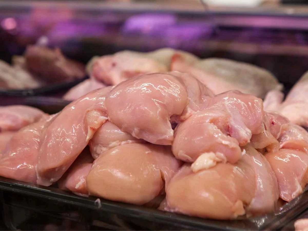 Raw chicken pieces displayed in a refrigerated meat counter.