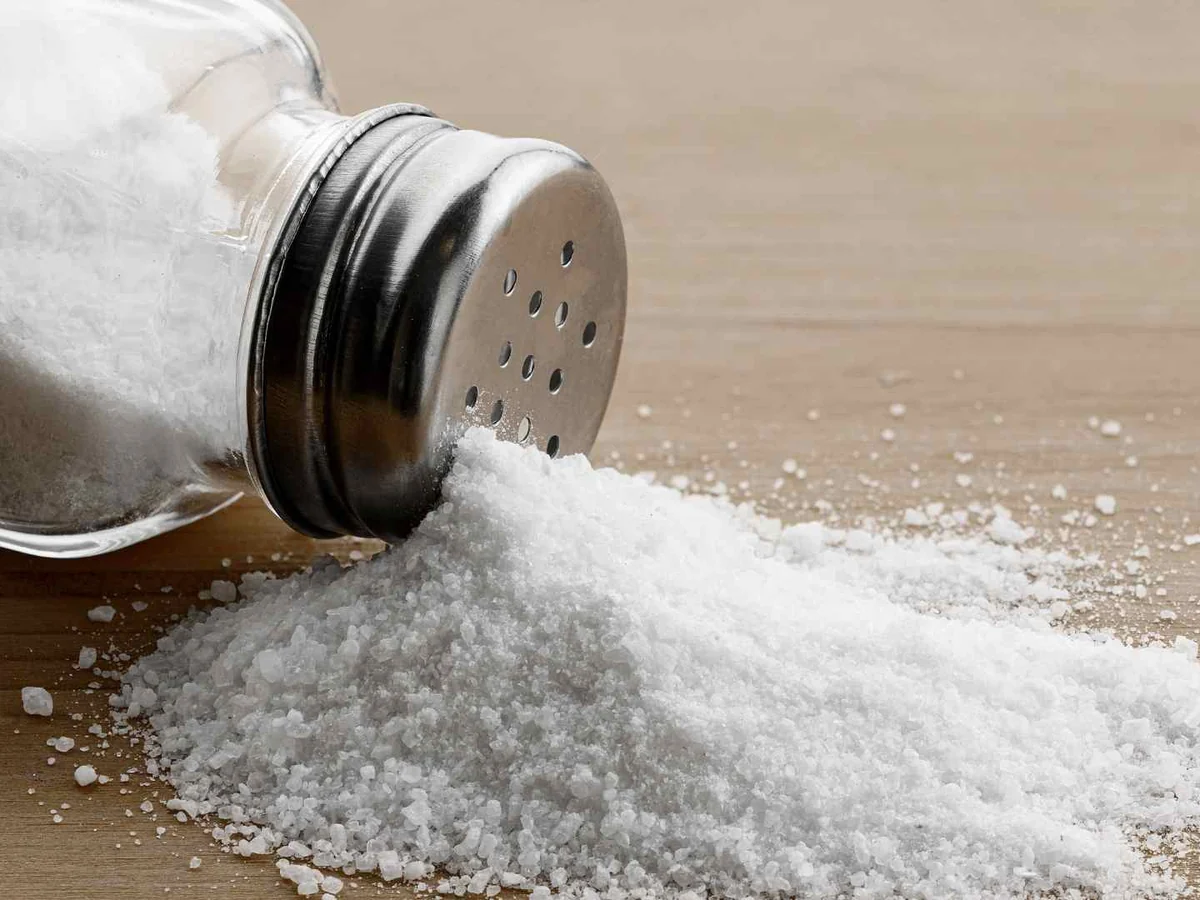 A salt shaker spilling fine white salt