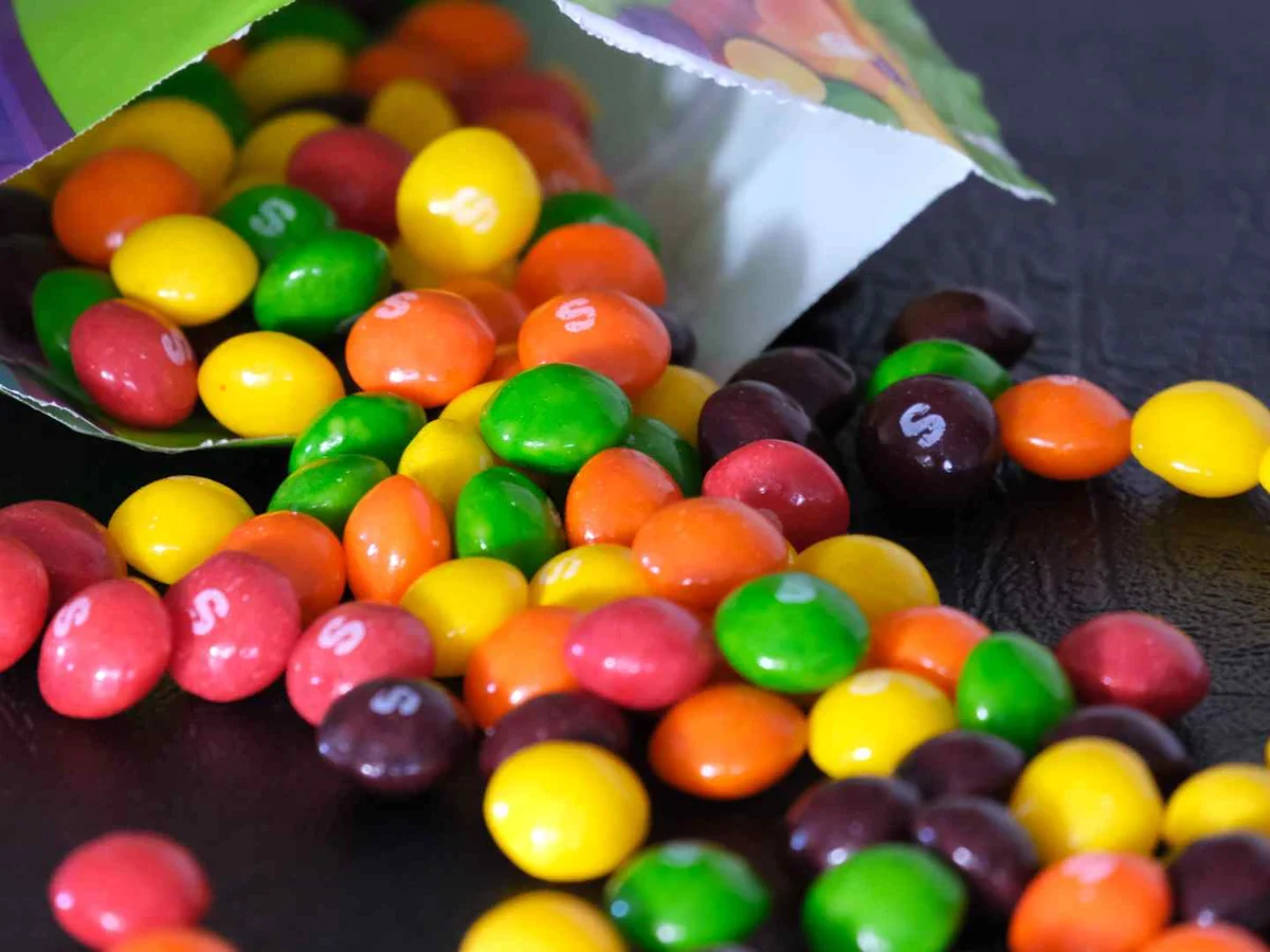 Colorful candy pieces spilling from a torn bag