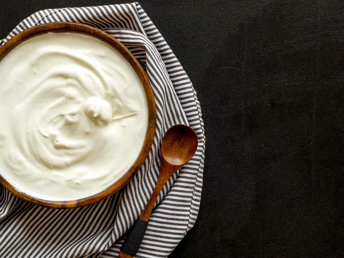 A bowl of sour cream on a striped cloth