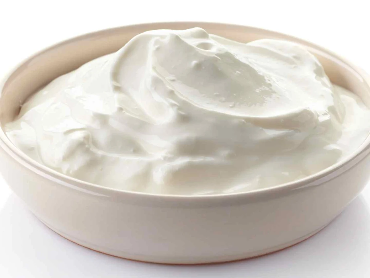A white bowl of sour cream isolated on white