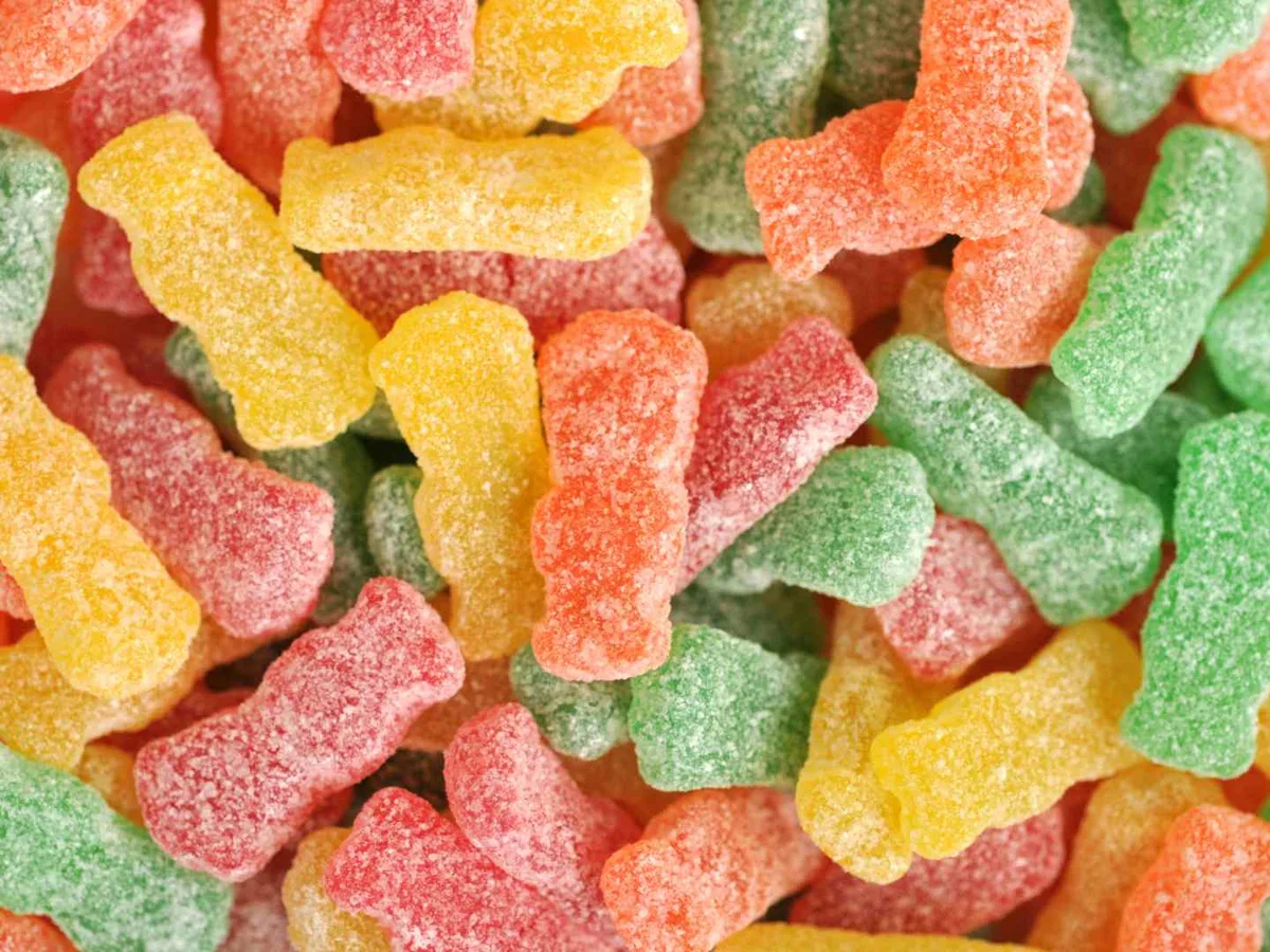 Red, orange, yellow, and green sour gummy candies coated in sugar.