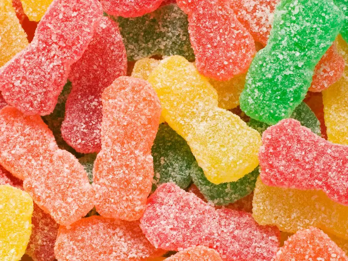 A close-up pile of sugar-coated sour gummy candies.