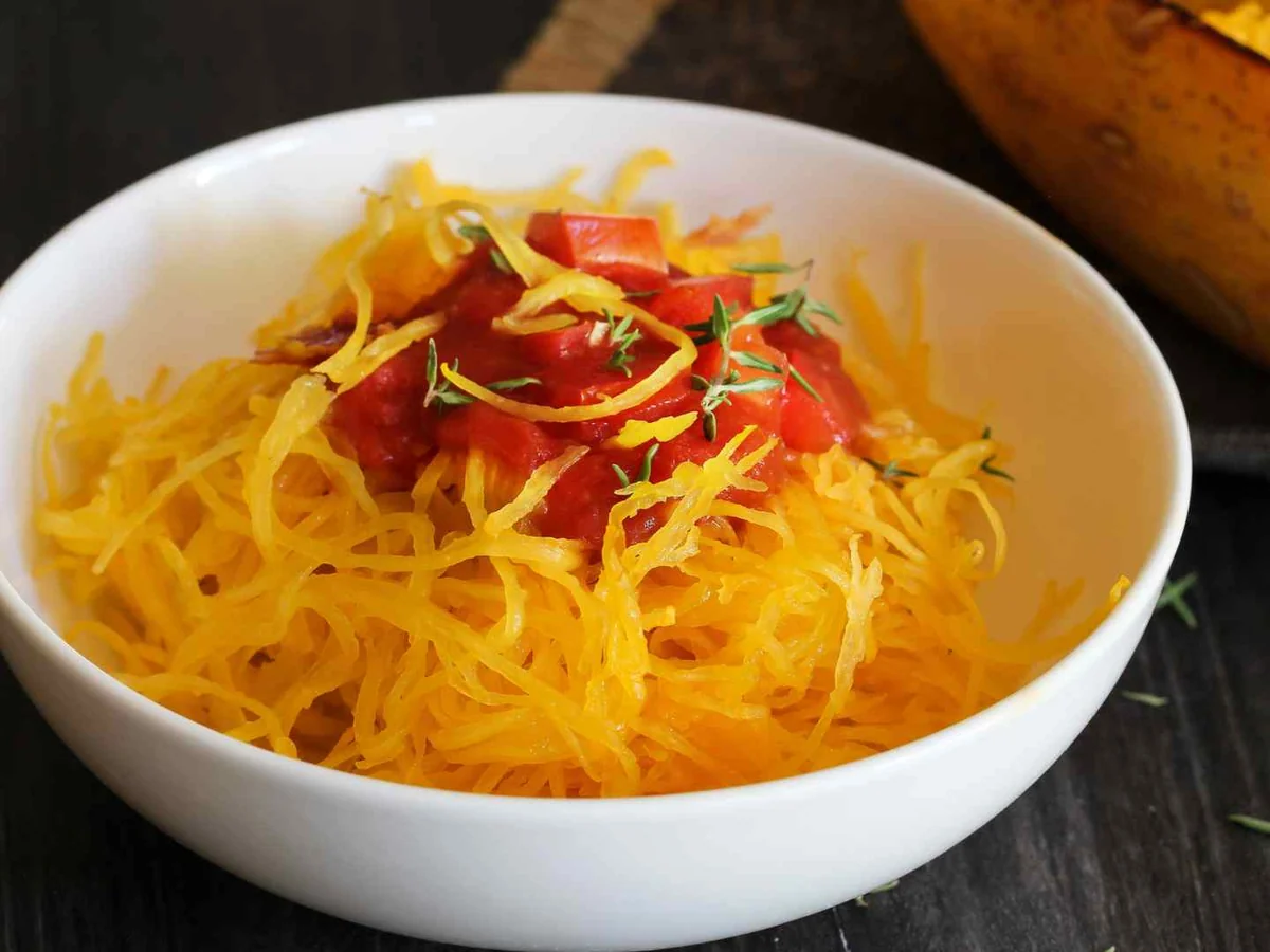 A bowl of spaghetti squash strands topped with vegetables