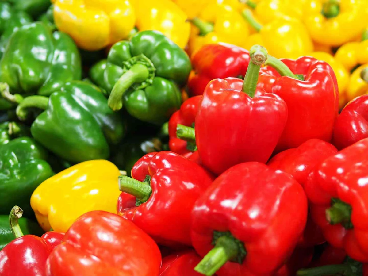 Bins of red, yellow, and green bell peppers