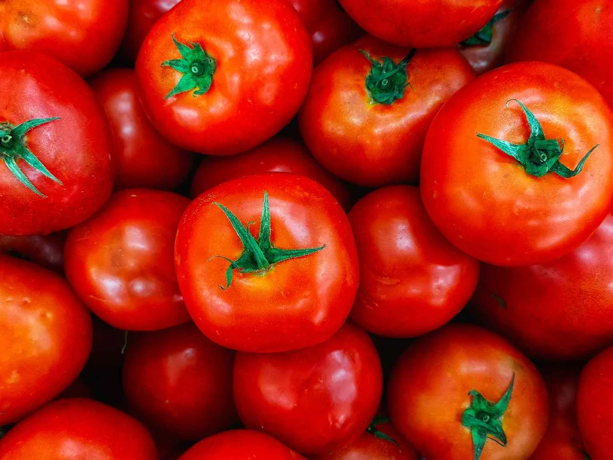 Ripe red tomatoes packed tightly together in a market display.