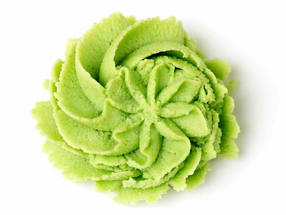 A decorative mound of pale green wasabi paste on white