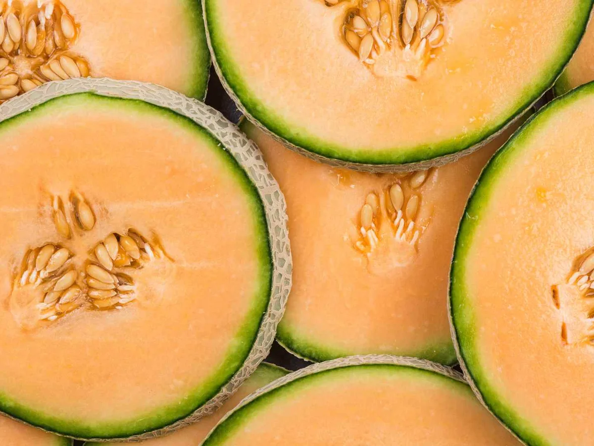 Overlapping cantaloupe halves showing orange flesh and seeds