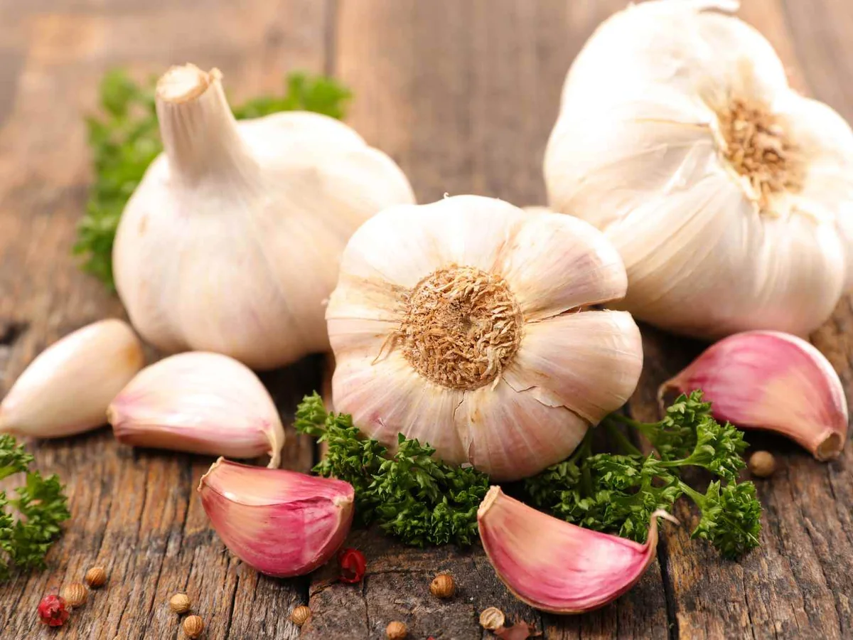 Garlic bulbs and pink-skinned cloves on a rustic table