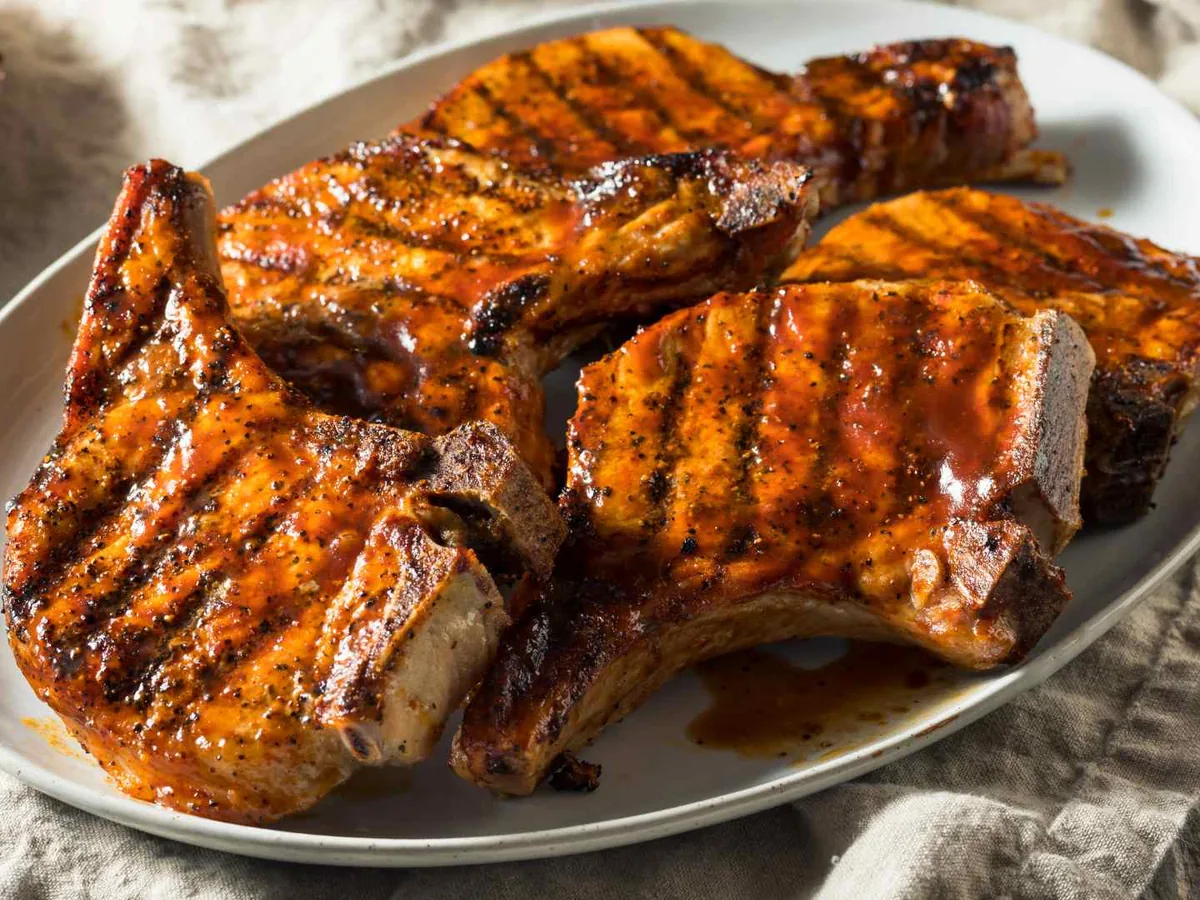 Grilled pork chops arranged on a serving plate