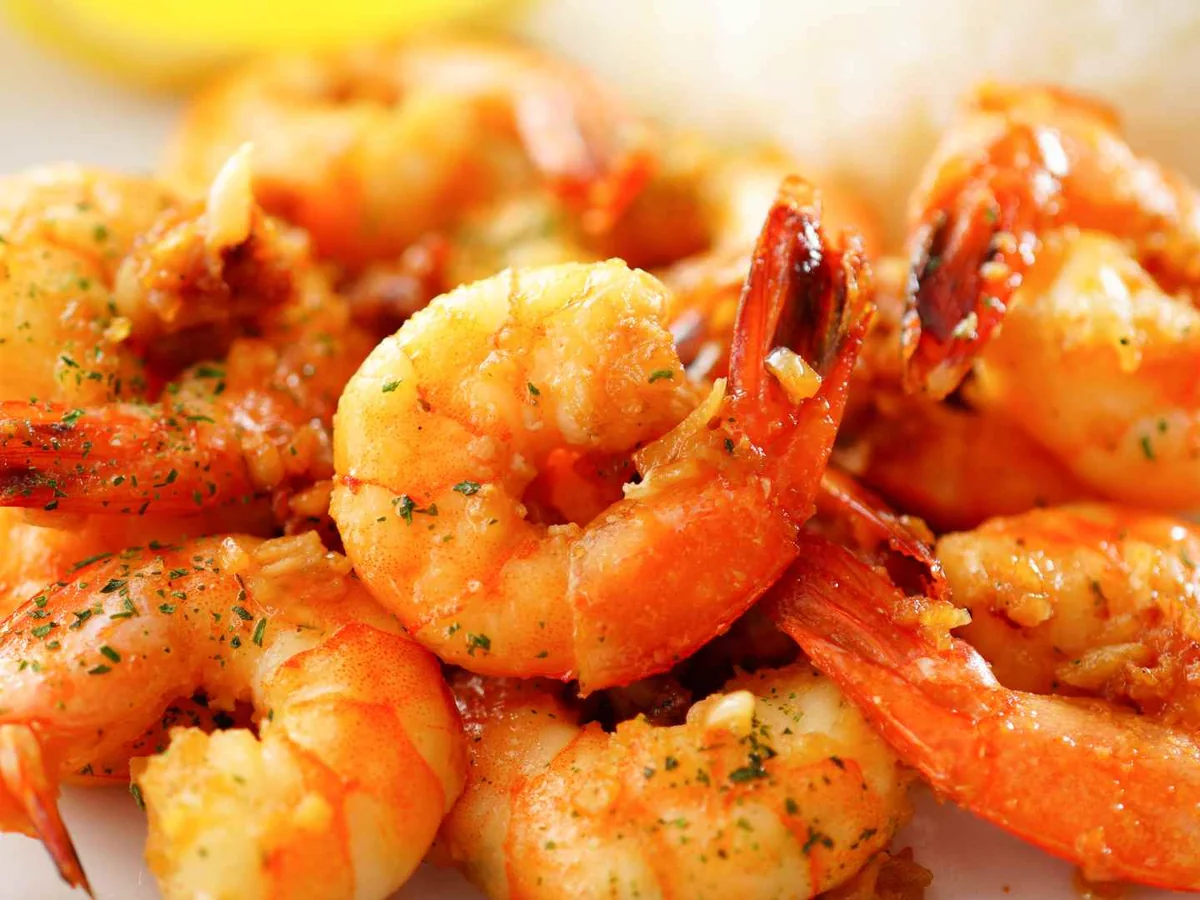 Cooked seasoned shrimp with tails on a white plate