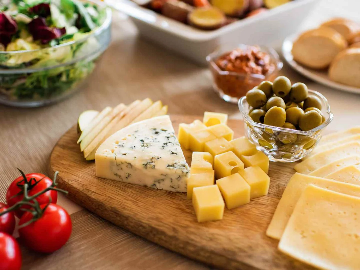 Assorted cheese wedges and cubes on a grazing board