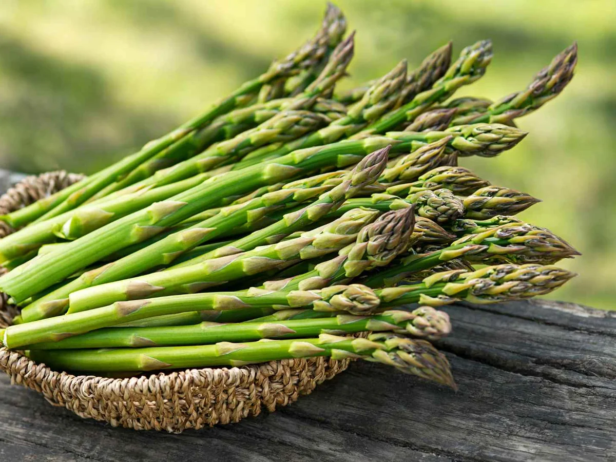A bundle of green asparagus spears on a rustic table