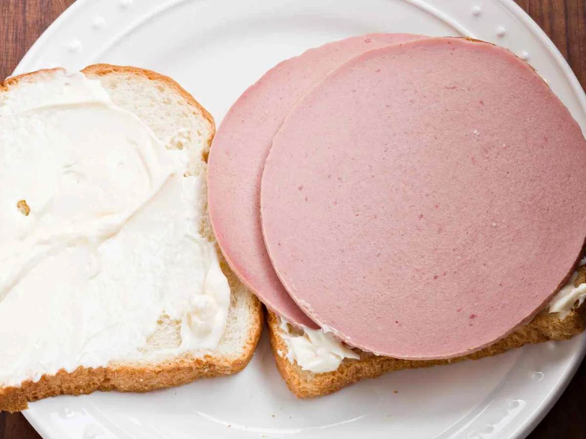 Open bread slices with mayonnaise and round bologna