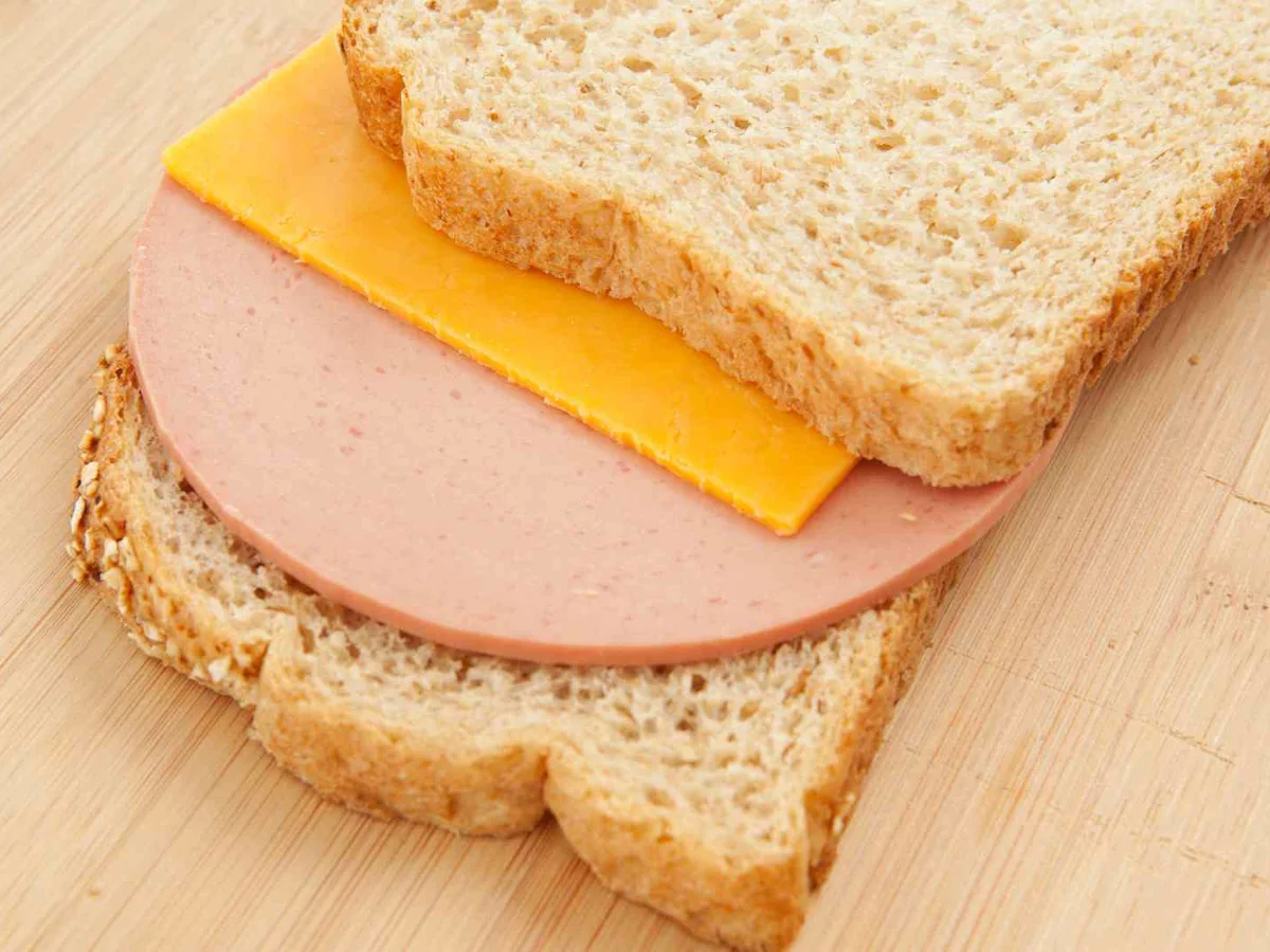 A bologna and cheese sandwich on wheat bread