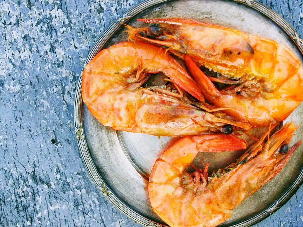 Cooked shell-on shrimp in a round glass bowl