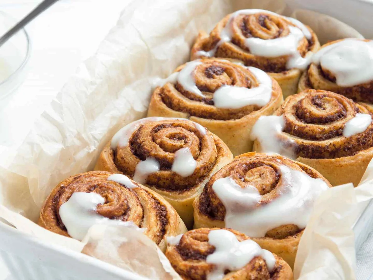A baking dish of cinnamon rolls topped with white icing