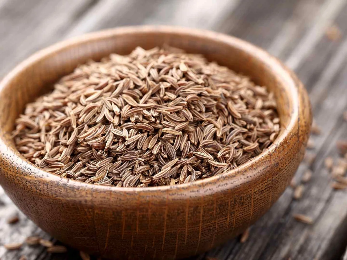 Cumin seeds filling a small wooden bowl