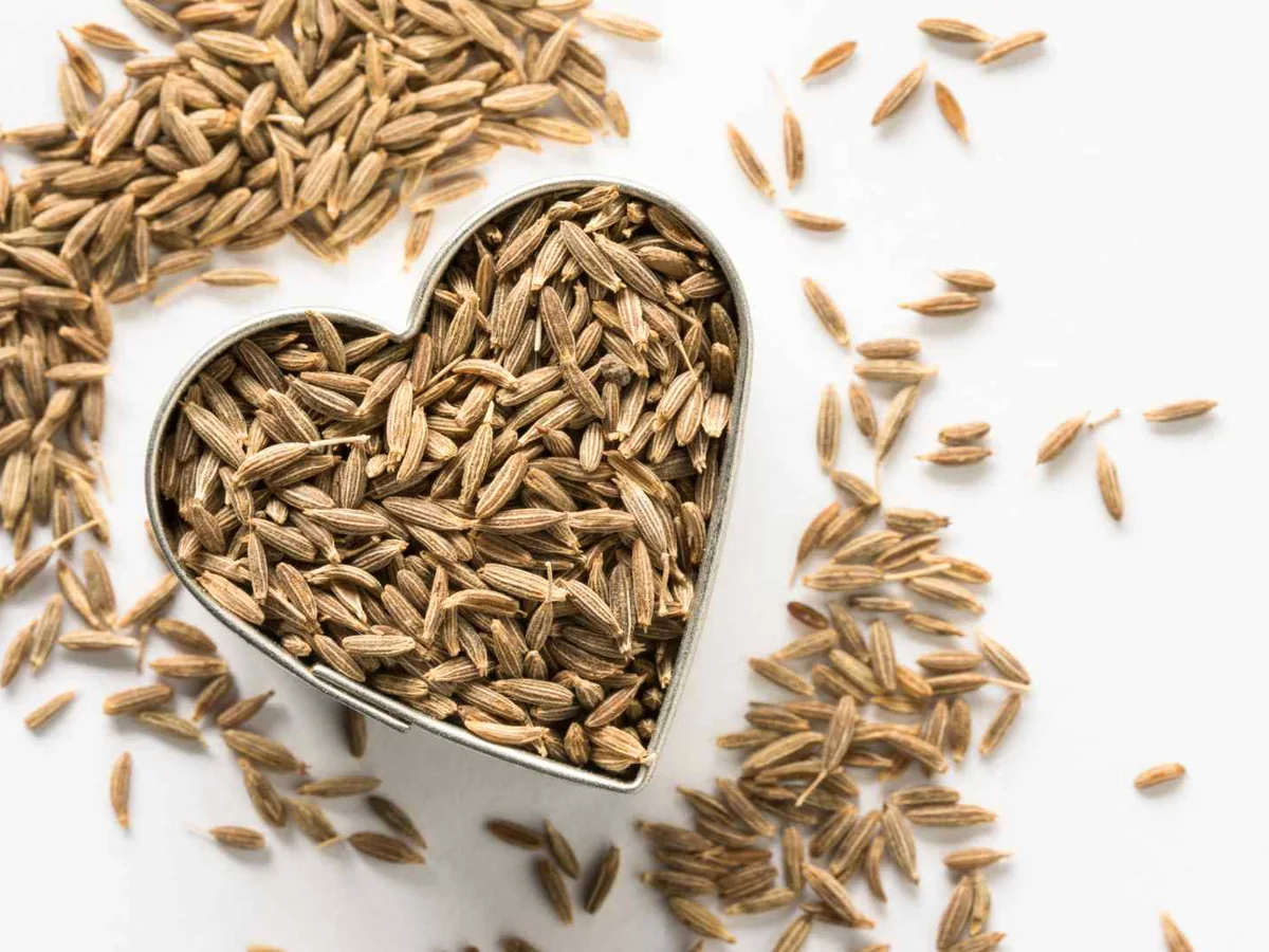 Cumin seeds surrounding a heart-shaped metal cutter