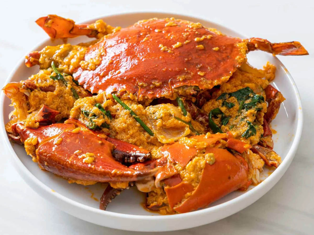 A cooked crab stuffed with seasoned filling on a white plate