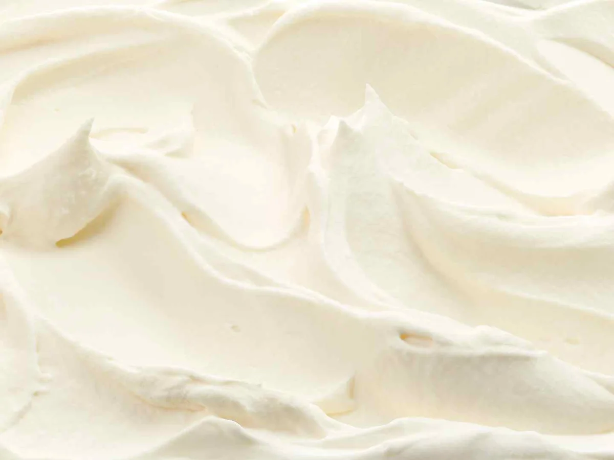 Close-up swirls of smooth white cream cheese