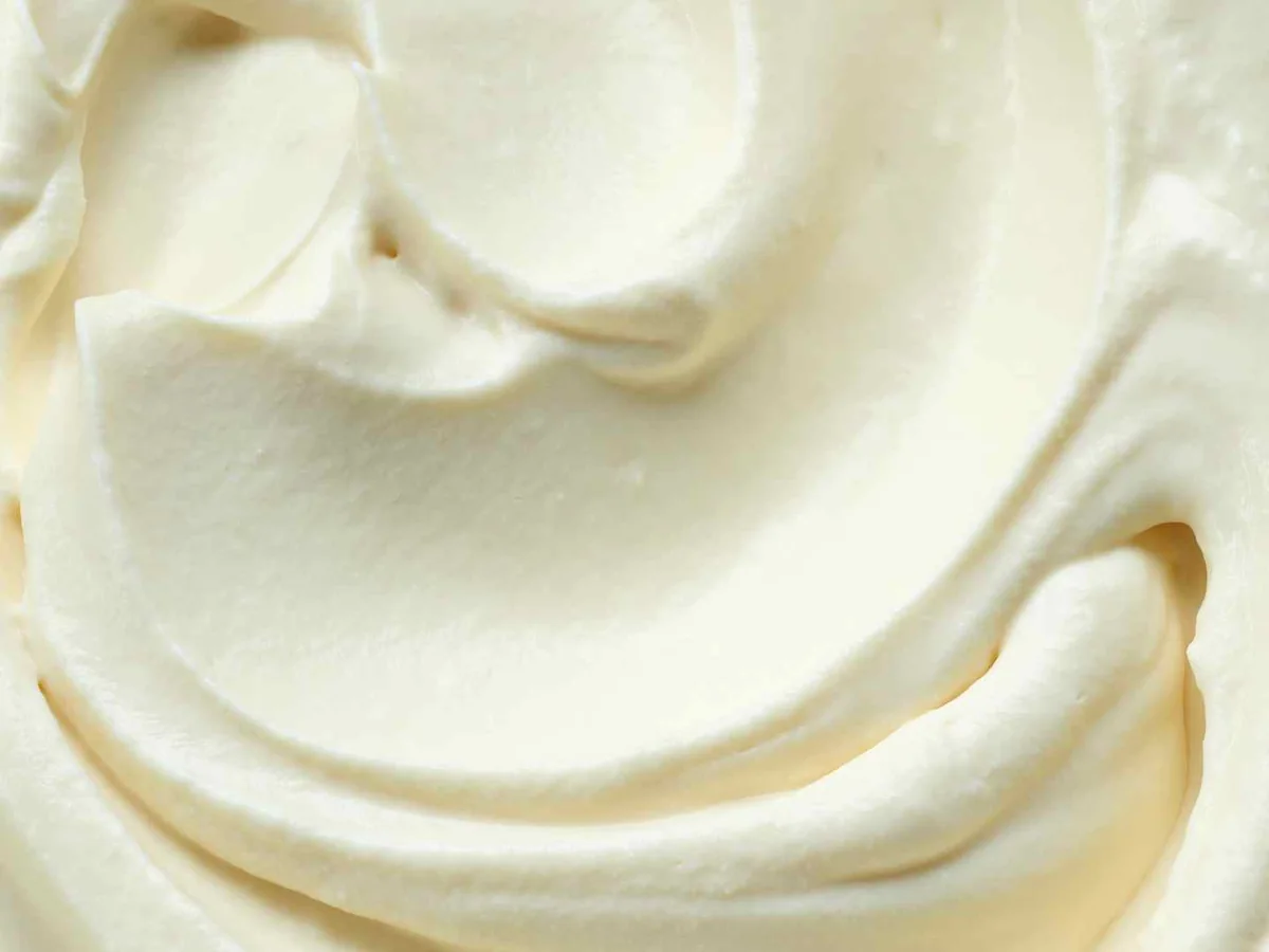 A spoon mark through smooth white cream cheese