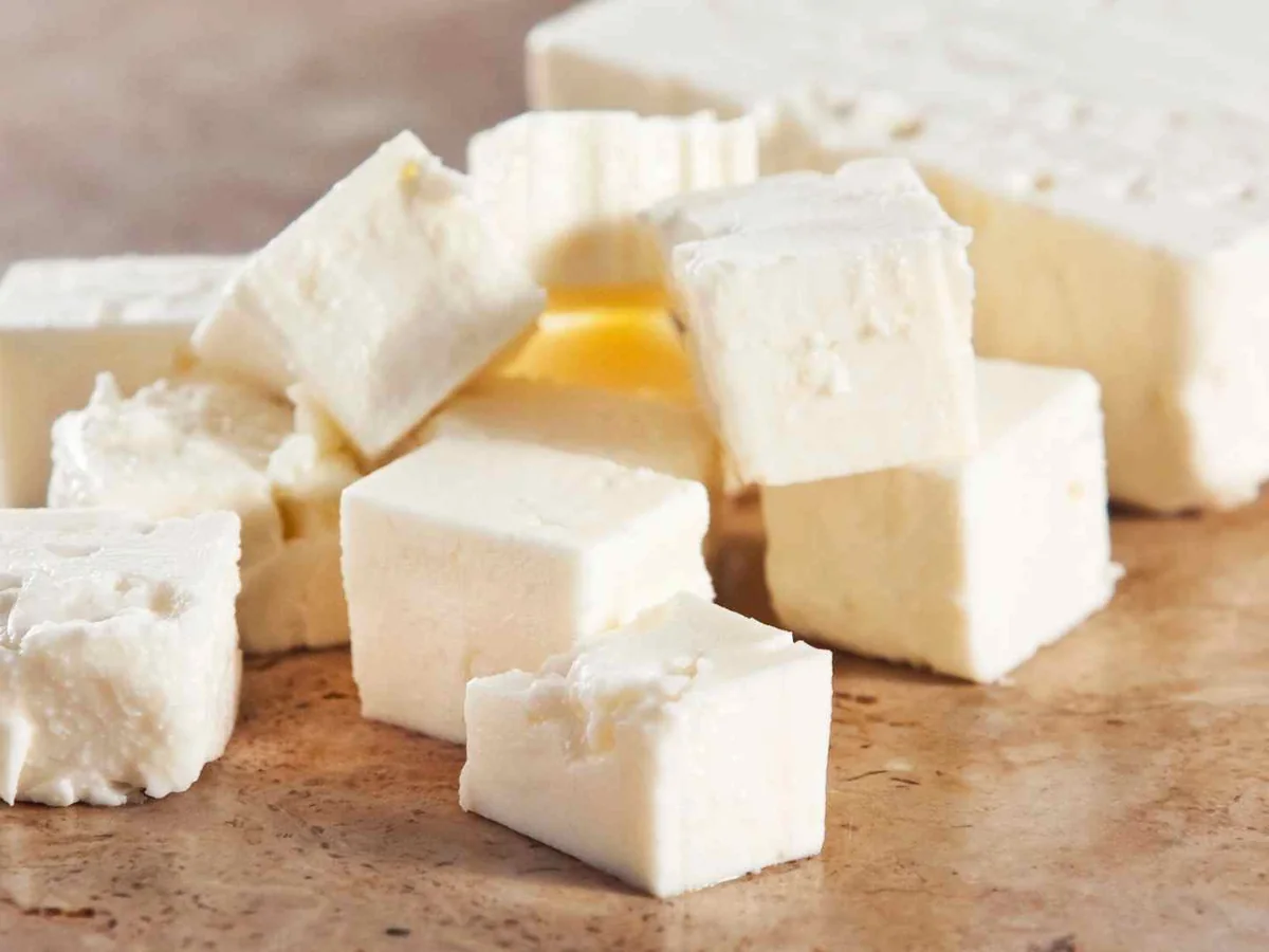Plain feta cubes and blocks on a wooden board