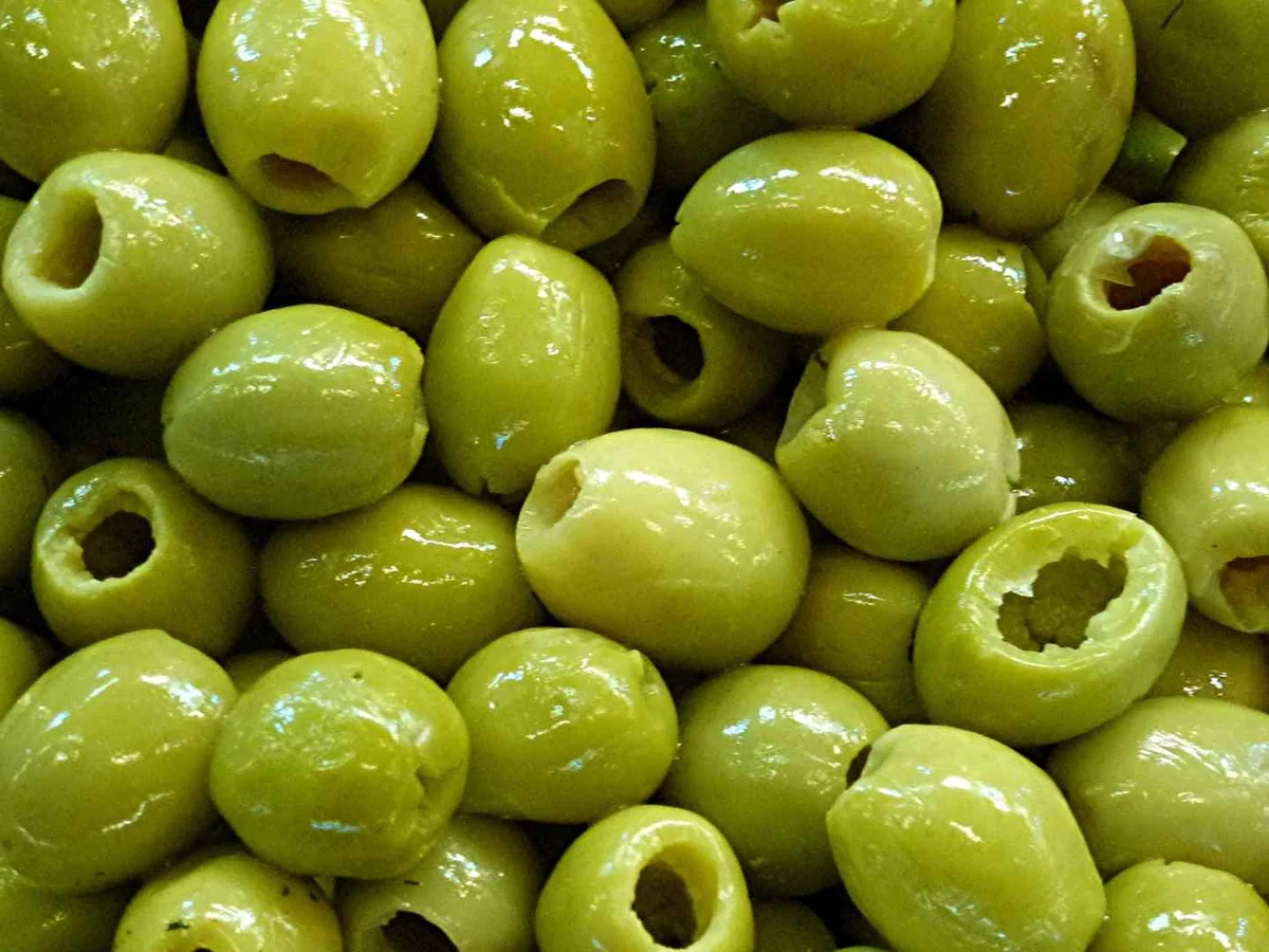Close-up pile of pitted green olives