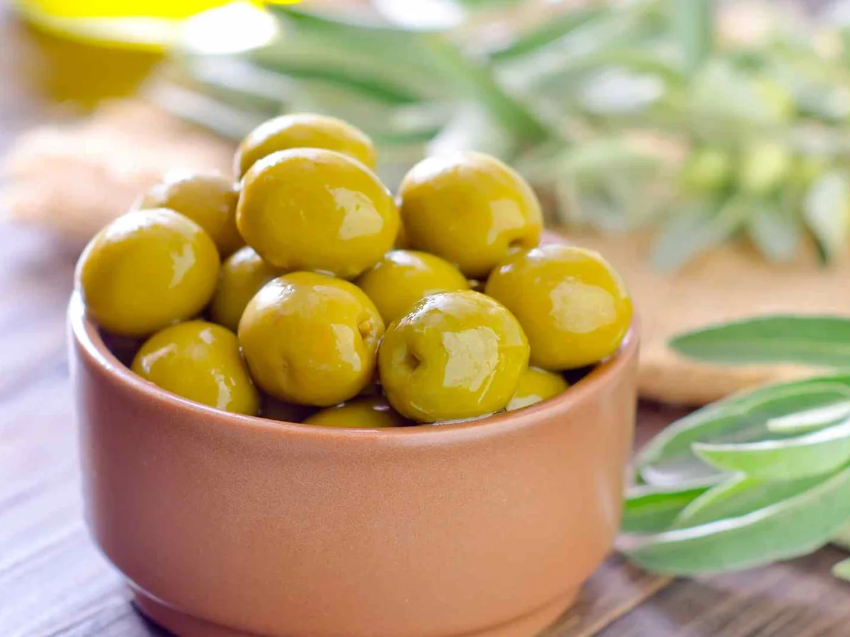 Green olives in a small ceramic cup