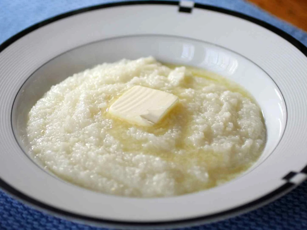 A bowl of creamy grits topped with a pat of butter