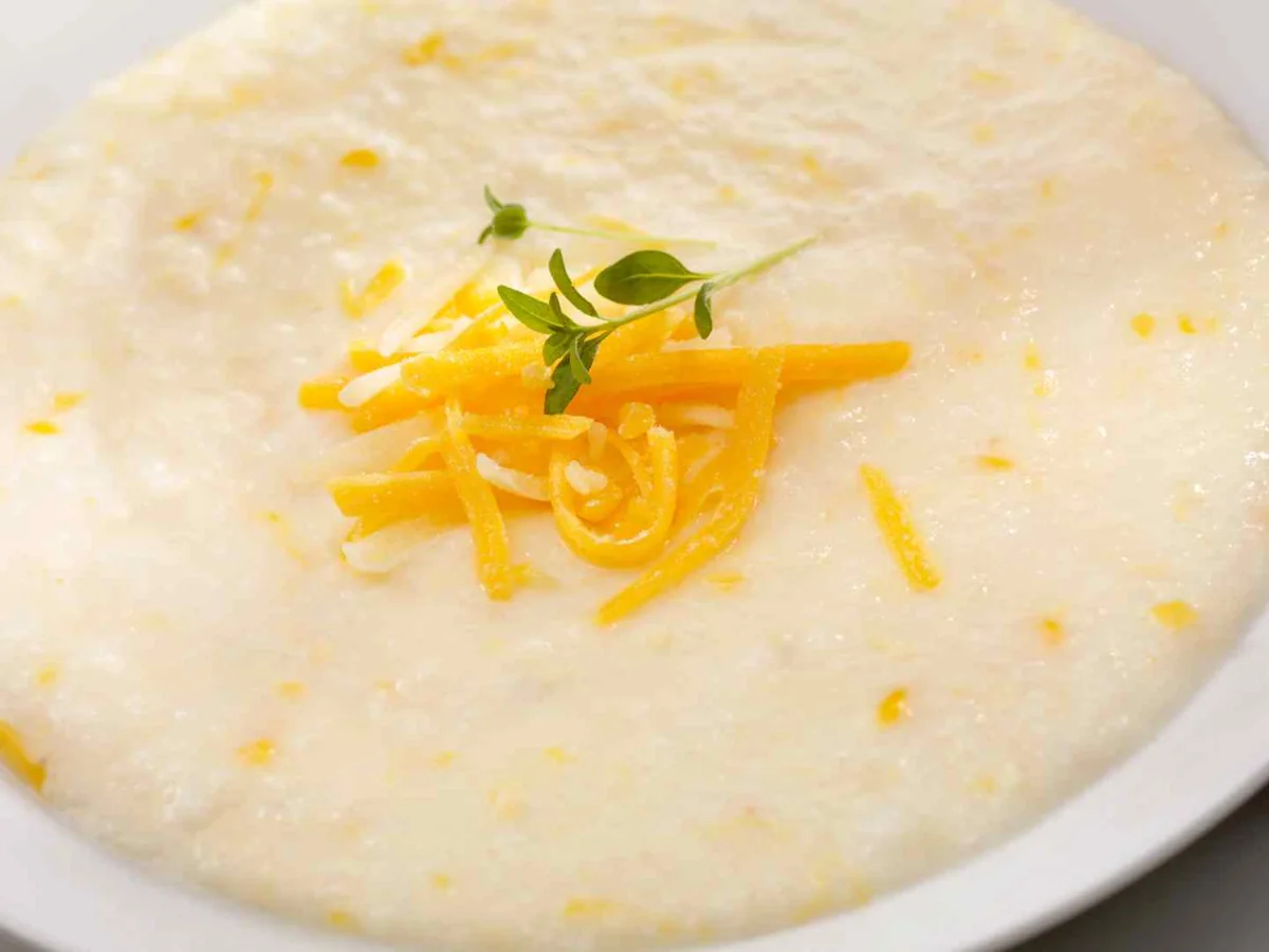 A bowl of creamy grits topped with shredded cheese