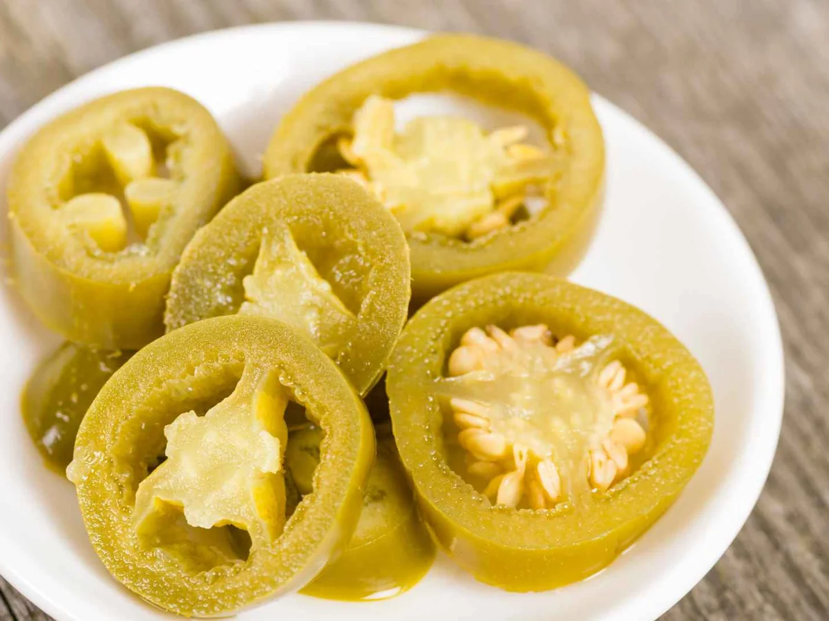 Sliced pickled jalapeños on a white plate