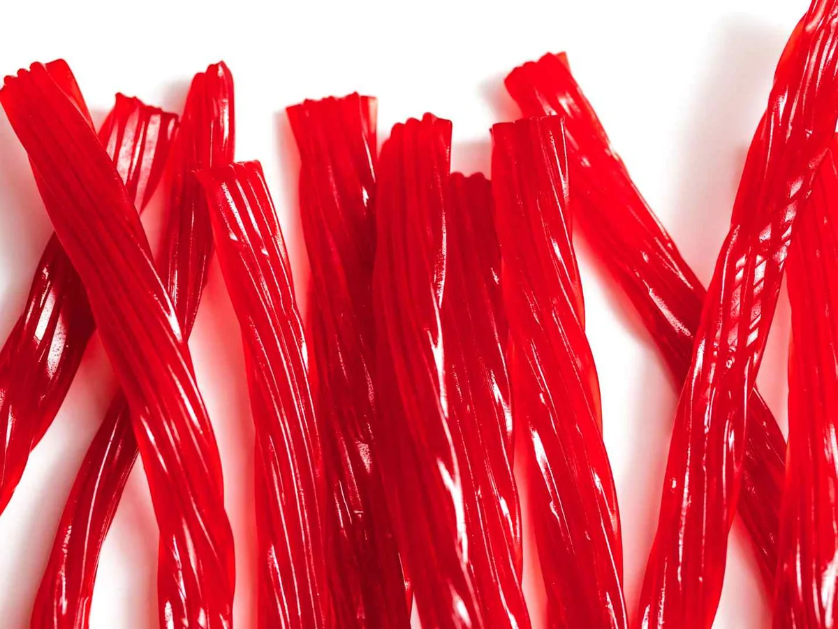 Red licorice sticks arranged on white